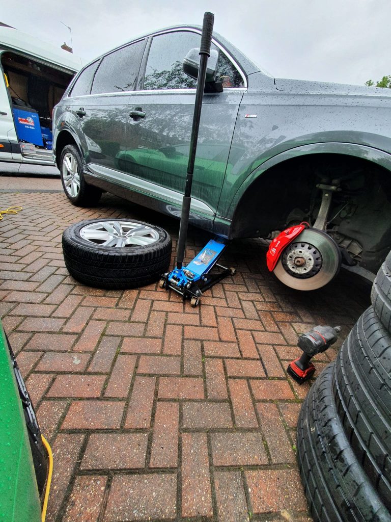 a car with a jack on the ground