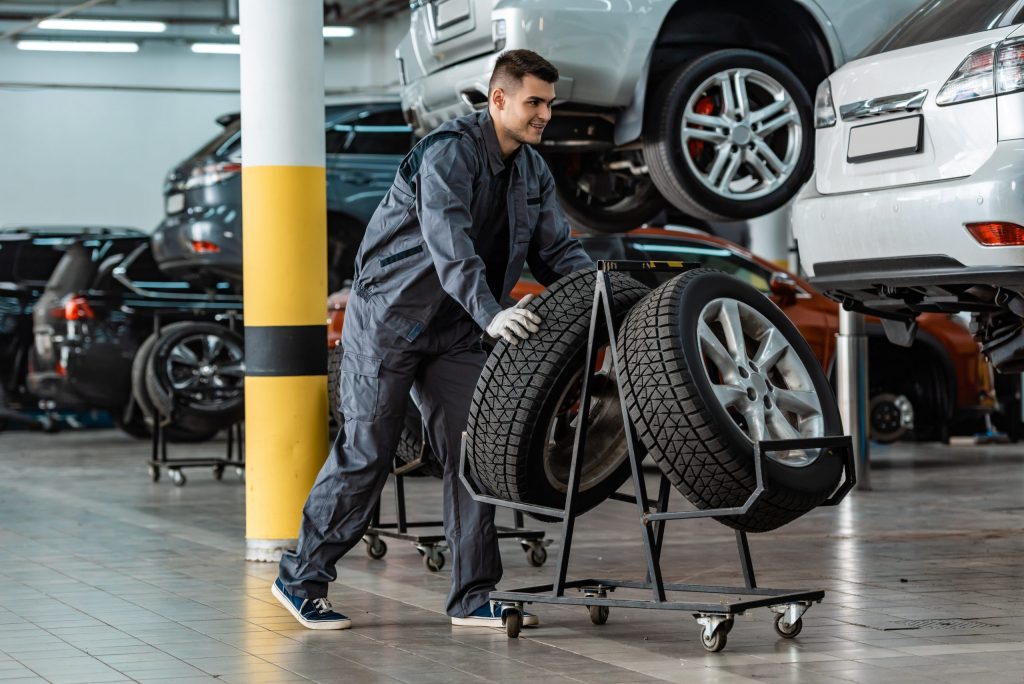a man in a garage with a car tire rack