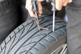 a person using screwdrivers to fix a tire